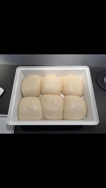 Sechs von Hand geformte Pizza Guys Teiglinge in einer Teigbox