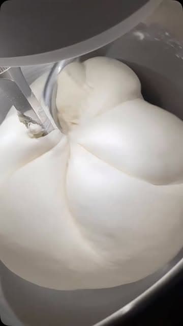 Glatter elastischer Pizzateig in der Knetmaschine